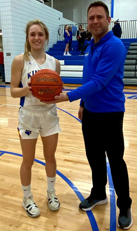 Coach Kuechle Handing Ellie the Game Ball.